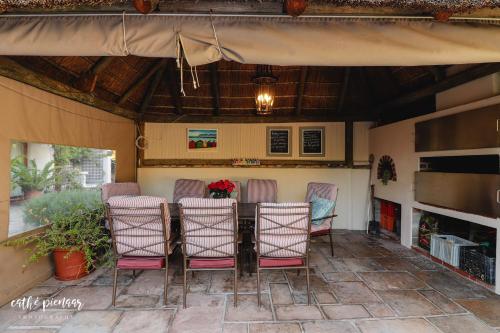 a group of chairs sitting around a table on a patio at A Tuscan Villa Guest House in Fish hoek