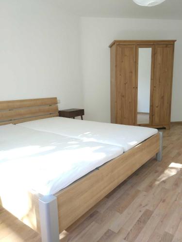a bedroom with a bed and a wooden cabinet at Sonnige EG_Wohnung mit Garten Terr in Forchheim