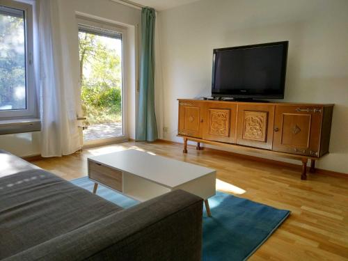 uma sala de estar com uma televisão de ecrã plano e um sofá em Sonnige EG_Wohnung mit Garten Terr em Forchheim