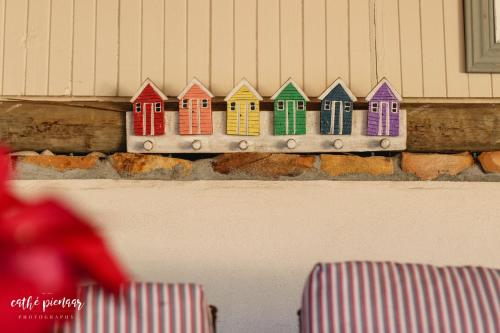 a row of colorful houses on top of a wall at A Tuscan Villa Guest House in Fish hoek