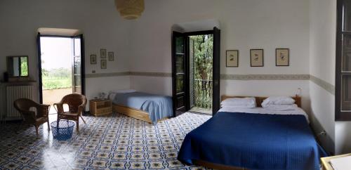 a bedroom with a blue bed and a window at Il Casino Di Mare - Dimora Storica in Santa Maria di Castellabate