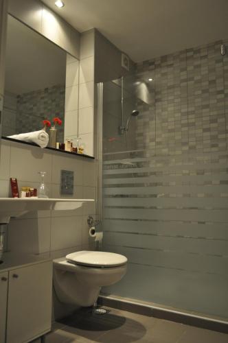 a bathroom with a toilet and a glass shower at Hotel Dolce International in Skopje