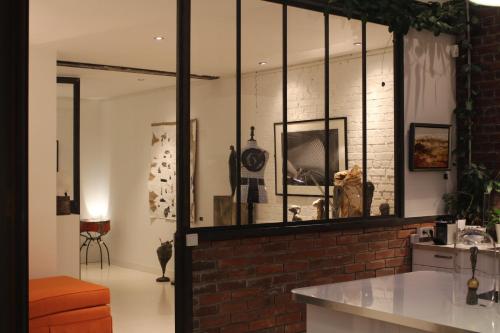 een kamer met een bakstenen muur en een spiegel bij Chambre d'hôtes la Teinturerie in Roubaix