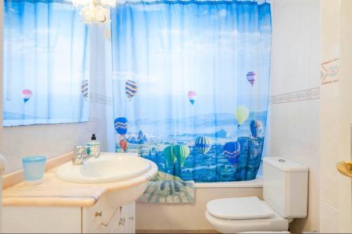 een badkamer met een wastafel, een toilet en een raam bij Apartment with Beach Views in Fuengirola