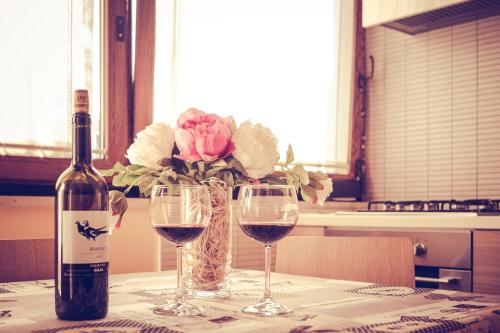 una mesa con dos copas de vino y un jarrón de flores en B&B La Casa Di Plinio, en Pompeya