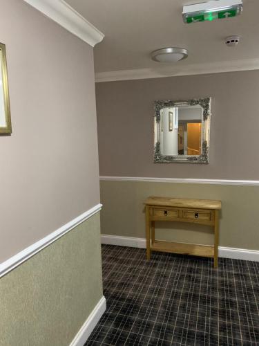 a dressing room with a table and a mirror at Royal Hotel in Dingwall