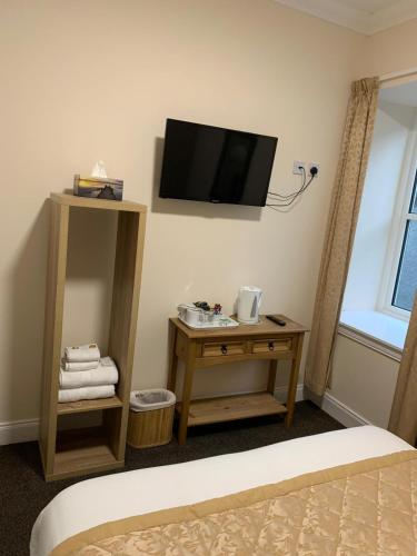 a room with a bed and a tv on the wall at Royal Hotel in Dingwall
