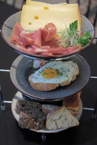 two plates of food with cheese and meat and bread at Maison Nationale City Flats & Suites in Antwerp