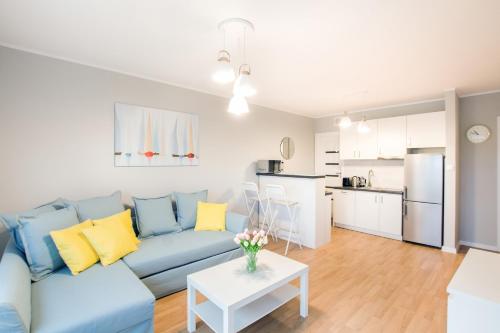 a living room with a blue couch and a table at Apartments Gdynia Na Fali with Parking by Renters in Gdynia