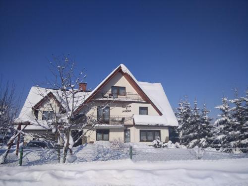 a house with snow on the roof of it at Czarna Jagoda in Czarna Góra