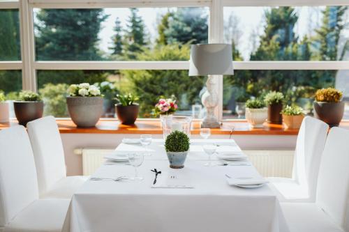 a white dining table with white chairs and a window at Hotel Europejski in Nysa