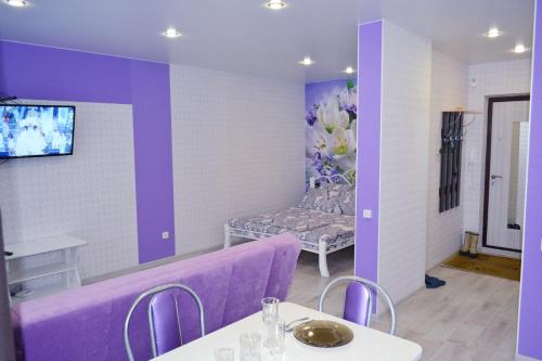 チェボクサルにあるApartment on Pirogova and Raduzhnayaの紫色の客室で、ソファ、テーブル、椅子が備わります。