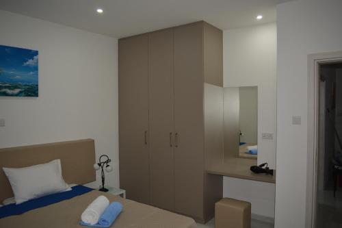 a bedroom with a bed with two towels on it at P.L Hermes Studios & Apartments in Larnaka