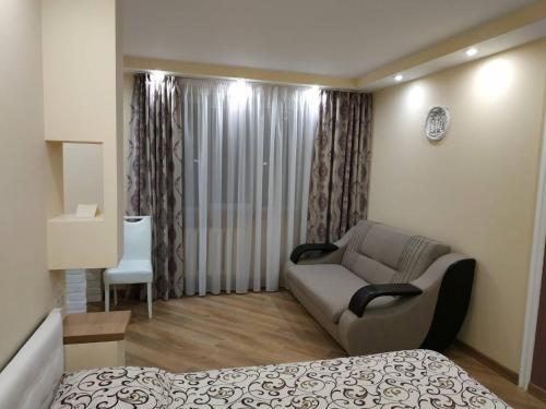 a bedroom with a bed and a couch and a chair at Apartments in the Center Maidan in Rivne