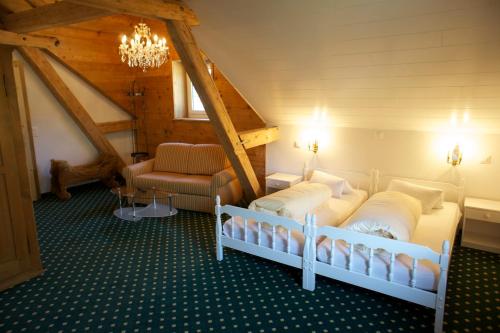 um quarto com duas camas e uma cadeira em Hotel Posta em Sedrun