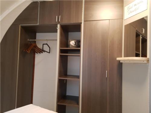 a closet with brown cabinets and a bed in a room at Iglo Bungalow 17 in Chaam