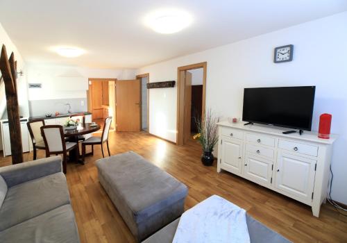 a living room with a couch and a tv and a table at Villa Rynek in Góra Świętej Anny