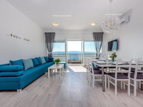 Una sala de estar con un sofá azul y un comedor. en Apartment in Croatia with Sea Views, en Dramalj