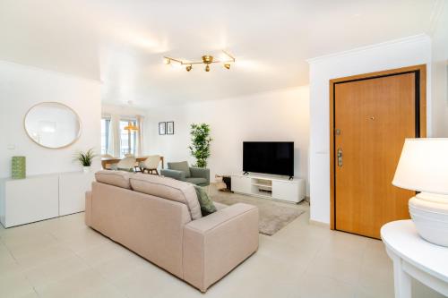 a living room with a couch and a television at LXLUXHOME - Casino Premium Apartment in Lisbon