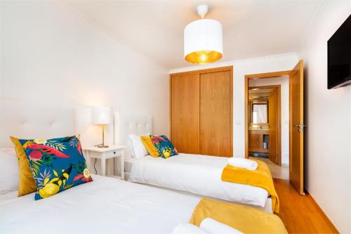 a bedroom with two beds and a tv in it at LXLUXHOME - Casino Premium Apartment in Lisbon