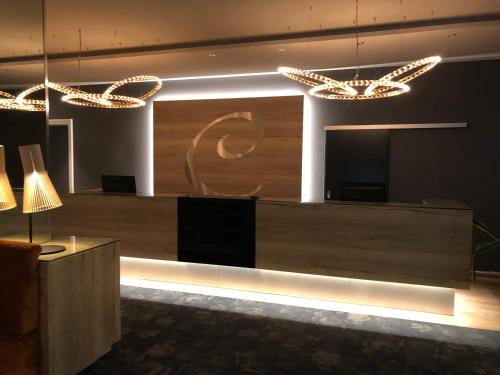 a lobby with a reception desk and lights at Caravelle Hotel im Park in Bad Kreuznach