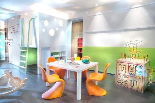 a dining room with a white table and orange chairs at Hapimag Ferienwohnungen Zell am See in Zell am See