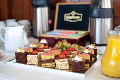 a tray of desserts on a table with a plate of food at Hotel Regina in Vienna