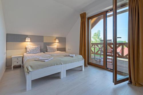 um quarto com uma cama e uma grande janela em Malinowe Wzgórze domki 90 m2 z sauną i balią- płatna em Krzeszna