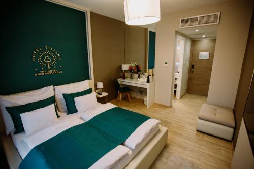 a bedroom with a large bed with a green wall at The Hotel Unforgettable - Hotel Tiliana by Homoky Hotels & Spa in Budapest