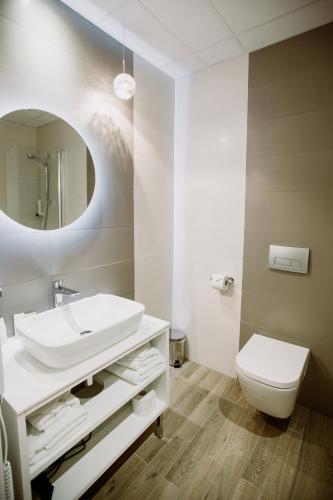 a bathroom with a sink and a toilet and a mirror at The Hotel Unforgettable - Hotel Tiliana by Homoky Hotels & Spa in Budapest