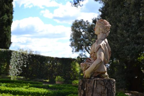 a statue of a woman sitting on a tree stump at Certosa di Pontignano Residenza d'Epoca - Place of Charme in Ponte A Bozzone