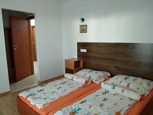 two twin beds in a bedroom with a headboard at Acopark Vendégház in Debrecen