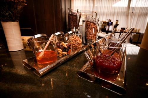 a table topped with glasses of drinks and a tray of food at Hotel VEGA Sofia in Sofia