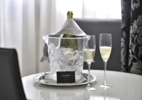 a bottle of wine and two glasses on a table at Al Theatro Palace in Venice