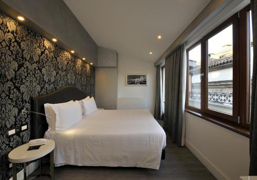 a hotel room with a large bed and a window at Al Theatro Palace in Venice