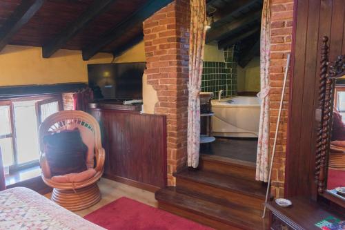 a living room with a tub and a chair in a room at Luna del Valle in Nueva de Llanes