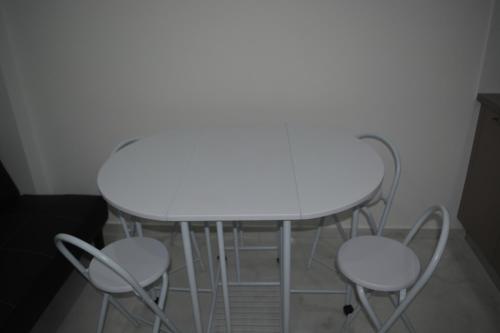 a white table and four chairs in a room at P.L Hermes Studios & Apartments in Larnaka