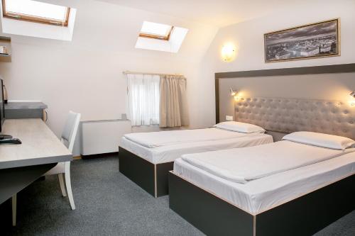 a hotel room with two beds and a desk at Hotel Niky in Sofia