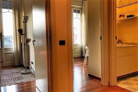 un couloir avec une porte ouverte sur une cuisine dans l'établissement Residenza in Palazzo d'Epoca, à Milan