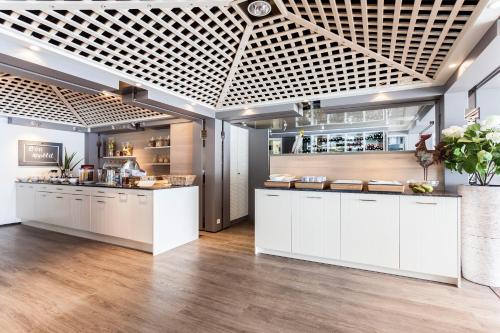 a large kitchen with white cabinets and a counter at Hotel Le Val D'arimont in Malmedy
