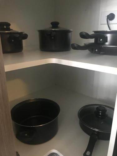 a kitchen with pots and pans on a shelf at New Luxurious Skyview 2Bedroom Apartment Liverpool in Liverpool