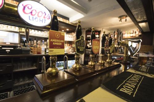 a bar with a counter with bottles of wine at The Bulls Head in Glossop