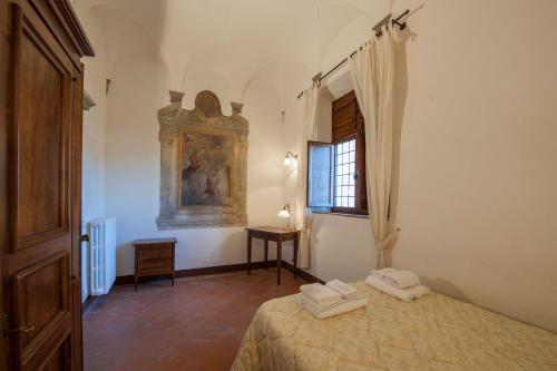a bedroom with a bed and a window and a painting at Certosa di Pontignano Residenza d'Epoca - Place of Charme in Ponte A Bozzone