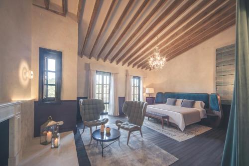 a bedroom with a bed and chairs in a room at Can Bordoy Grand House Hotel GL Preferred Hotel in Palma de Mallorca