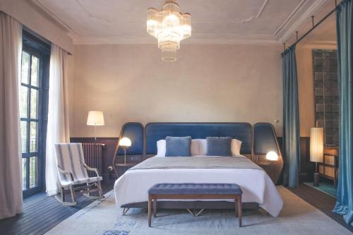 a large bedroom with a large bed and a chandelier at Can Bordoy Grand House Hotel GL Preferred Hotel in Palma de Mallorca