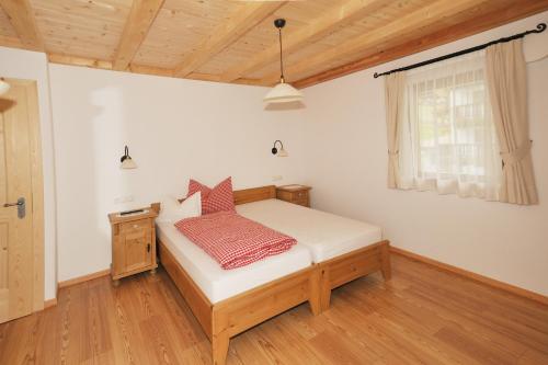 a small bedroom with a bed and a window at Apartments Isgla in Selva di Val Gardena