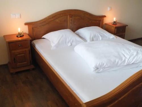 アルバ・ユリアにあるCamere de inchiriat Oneliaのベッド(白いシーツ付)、キャンドル付きの2泊スタンド