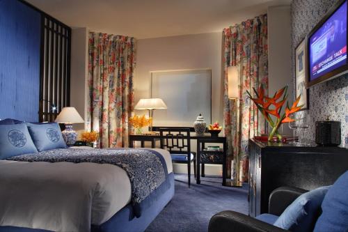 a hotel room with a bed and a television at Orchard Hotel Singapore in Singapore