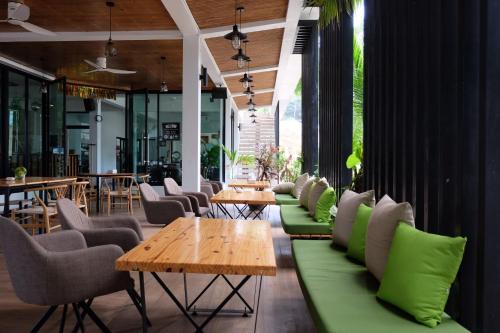 a restaurant with green couches and tables and chairs at Simple Life Cliff View Resort in Koh Tao