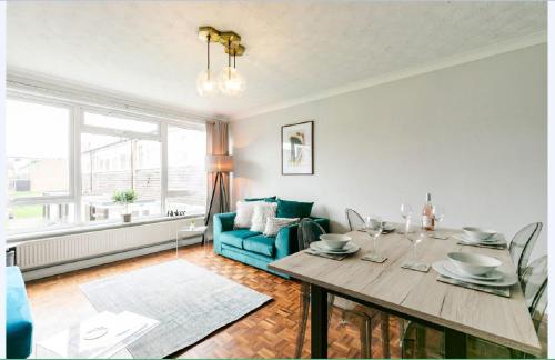 a living room with a table and a blue couch at Gayton Court 2-Bedroom Flat in the Centre of Reigate in Reigate